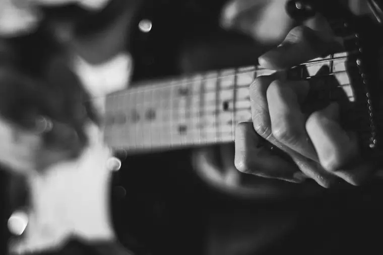 Le manche d’une guitare électrique : à quatorze ans, il en jouait déjà mieux que les deux autres.